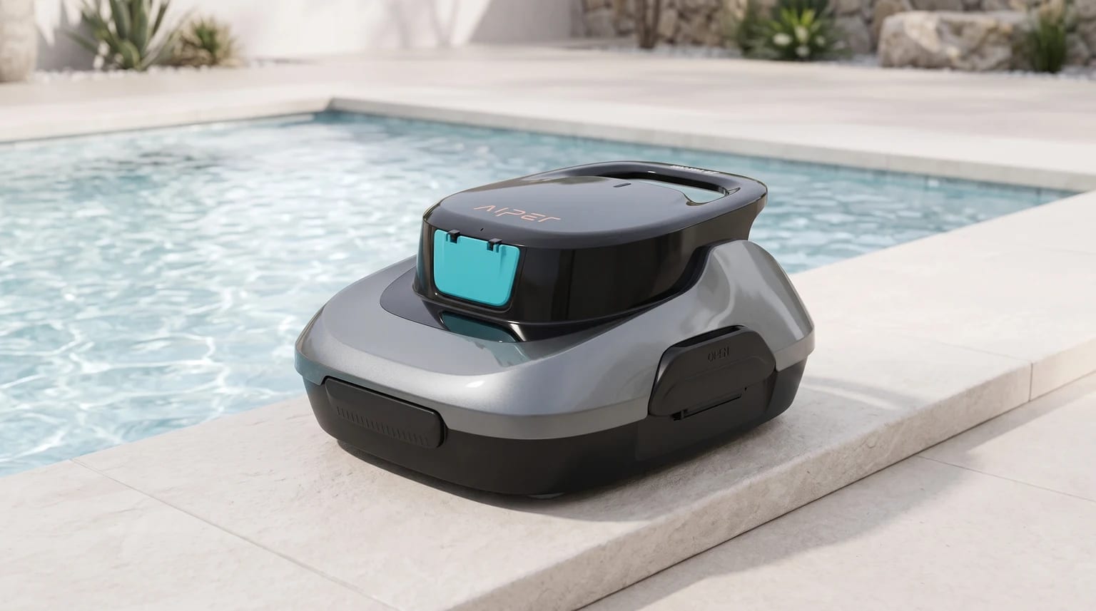 Robot de piscina AIPER Scuba SE, cinzento e preto com detalhe azul-turquesa, na borda de pedra de uma piscina.