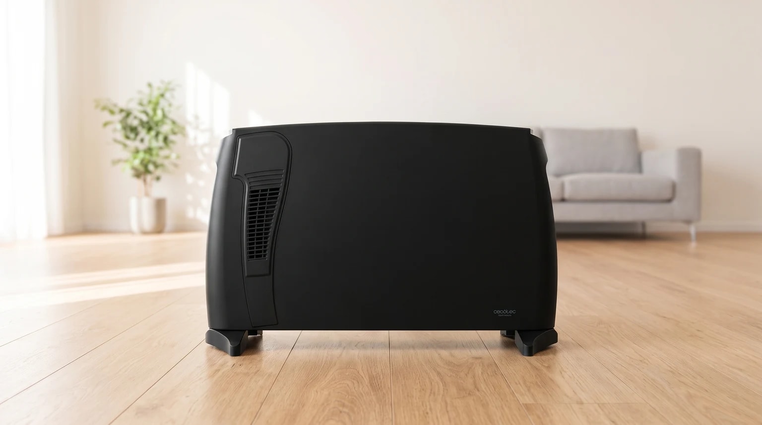 Convector elétrico preto da Cecotec sobre um chão de madeira, com uma sala de estar luminosa ao fundo.