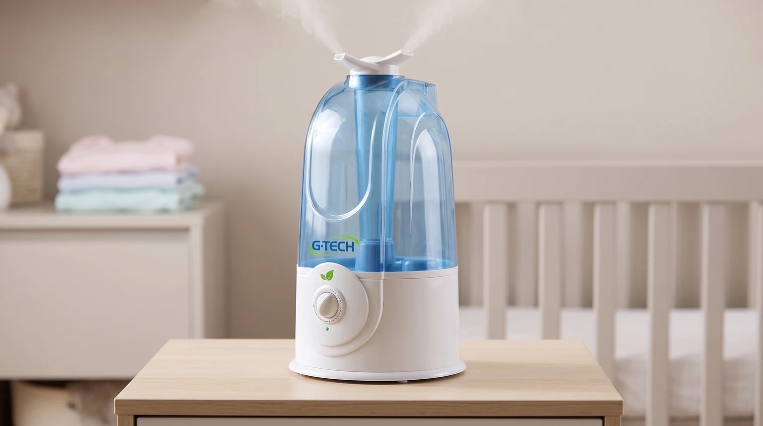 Umidificador G-Tech branco com tanque azul e saída dupla, liberando névoa sobre um móvel em um quarto de bebê.