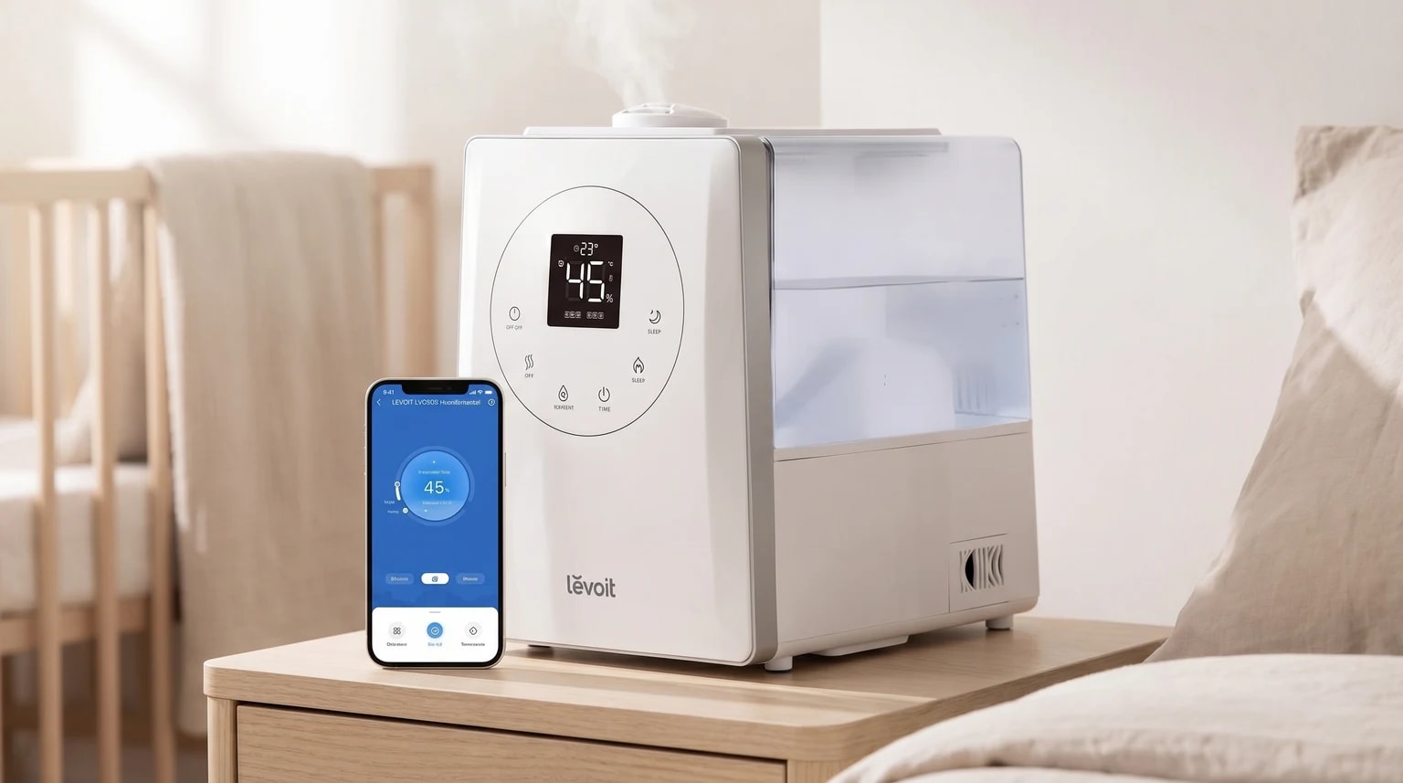 Humidificador branco da Levoit a funcionar numa mesa de cabeceira de madeira clara, num quarto de bebé luminoso e sereno, com uma suave névoa visível.