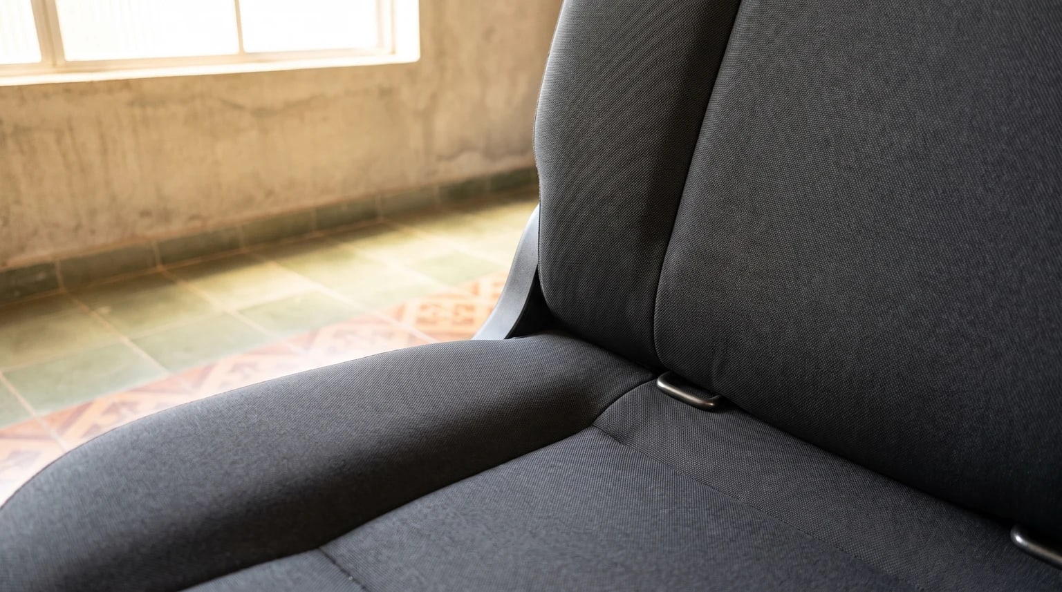 Duas ancoragens inferiores ISOFIX na junção entre o assento e o encosto do banco traseiro.
