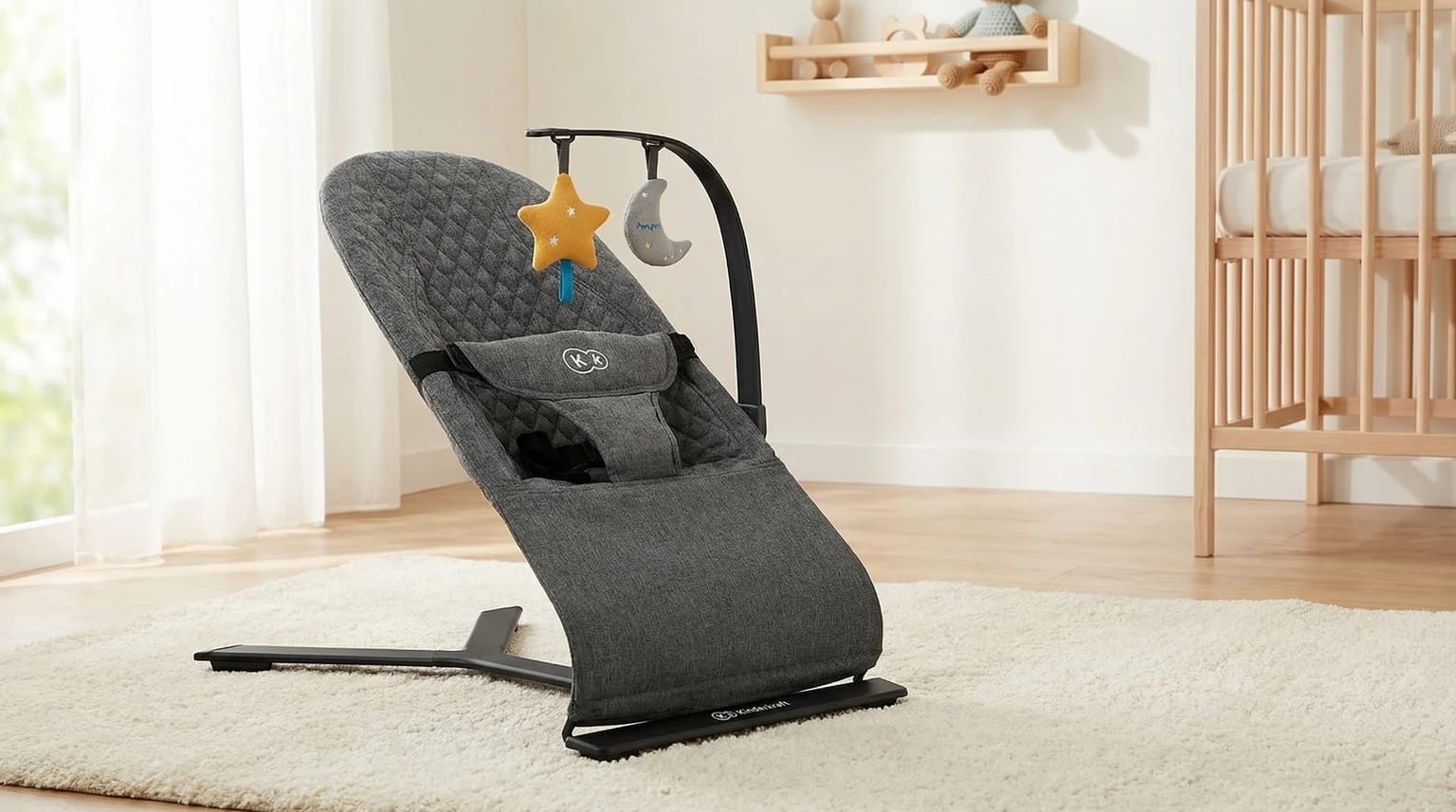 Espreguiçadeira cinzenta Kinderkraft MIMI num quarto de bebé moderno e luminoso, com luz natural suave.