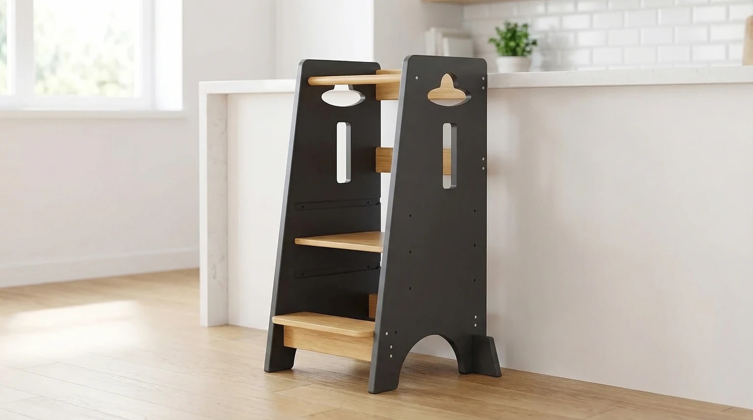 Torre de aprendizagem cinzenta e em madeira encostada a uma bancada de cozinha clara e moderna.