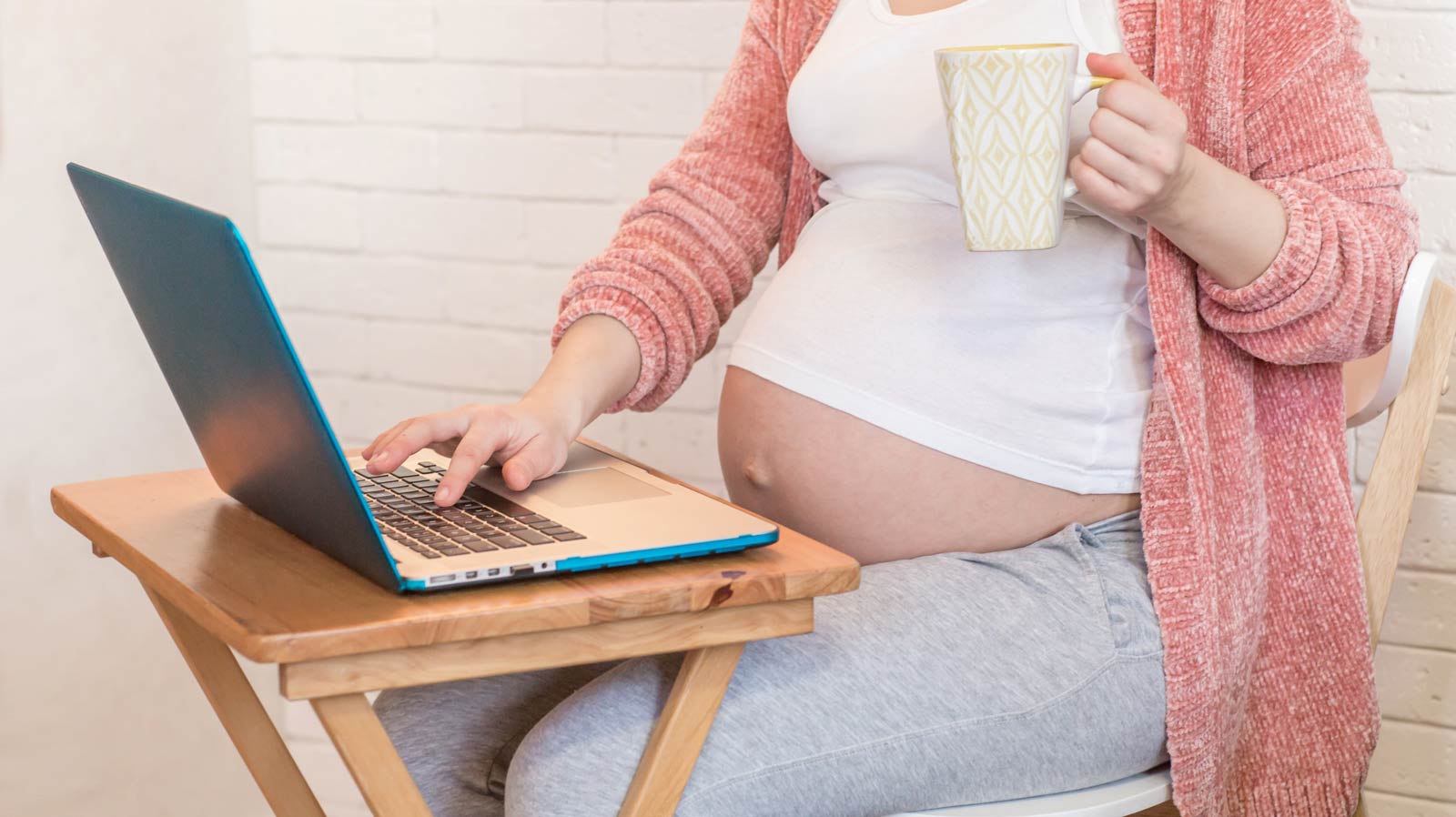 Mulher grávida a usar um laptop