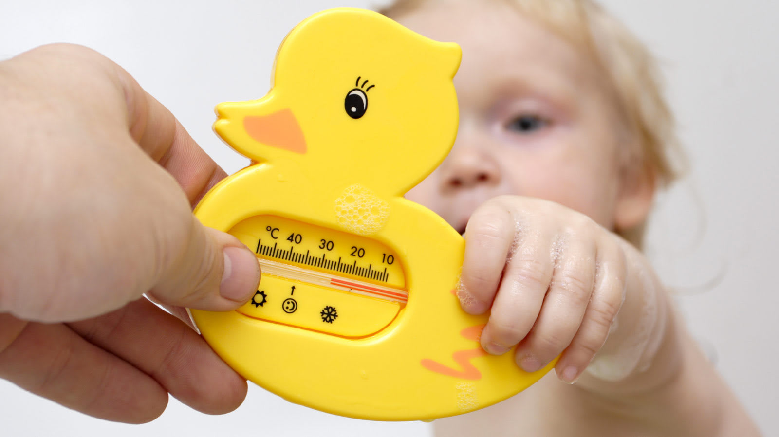 Criança segurando termómetro com formato de pato