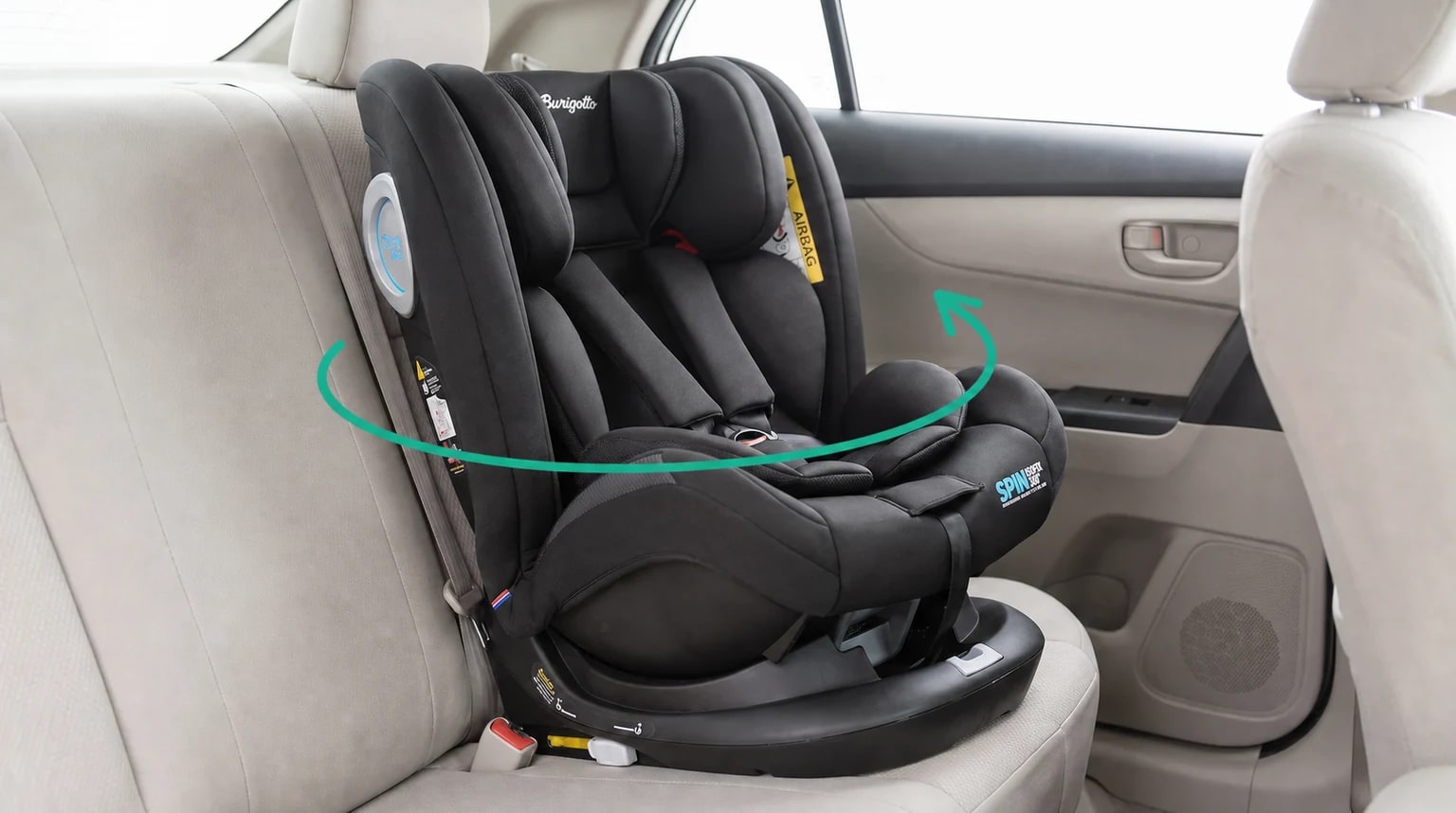 Cadeirinha Burigotto Spin ISOFIX 360° preta instalada no banco traseiro, com uma seta turquesa indicando o giro.