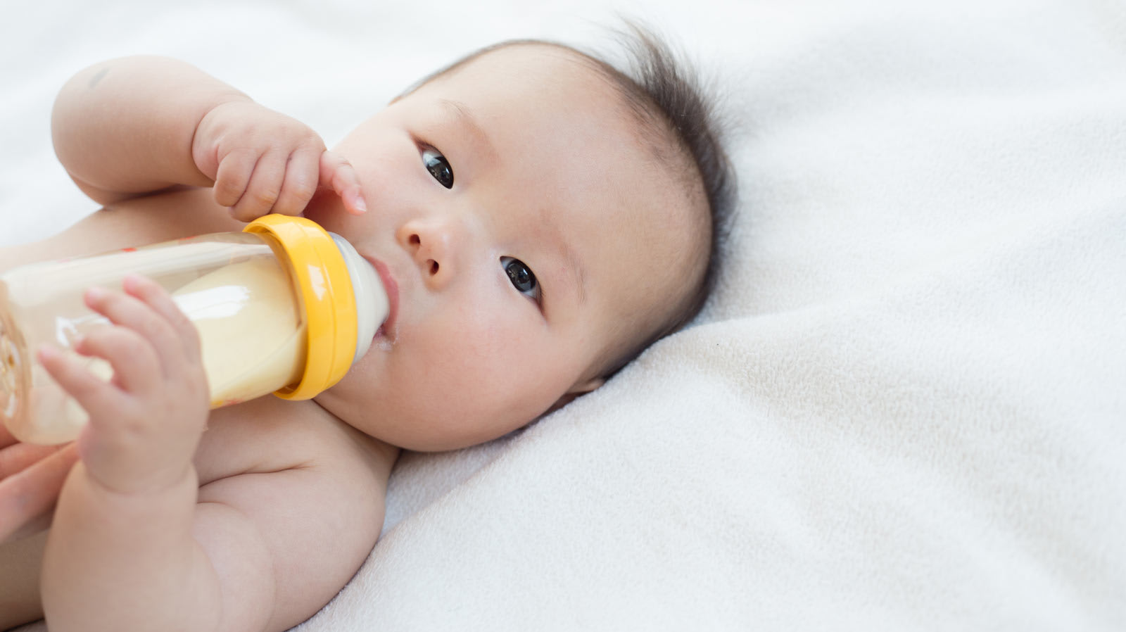 Un bebé bebiendo leche de un biberón Medela.