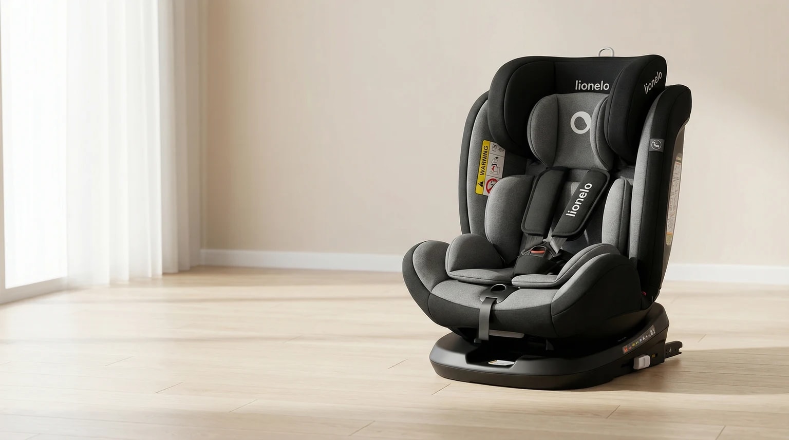 Cadeira auto Lionelo Bastiaan preta e cinzenta num ambiente interior claro com parede suave, chão claro e luz natural.